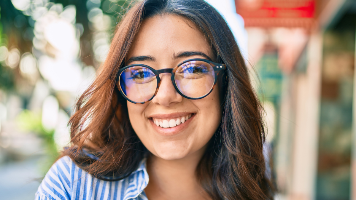 Young hispanic businesswoman smiling happy walking at the city.