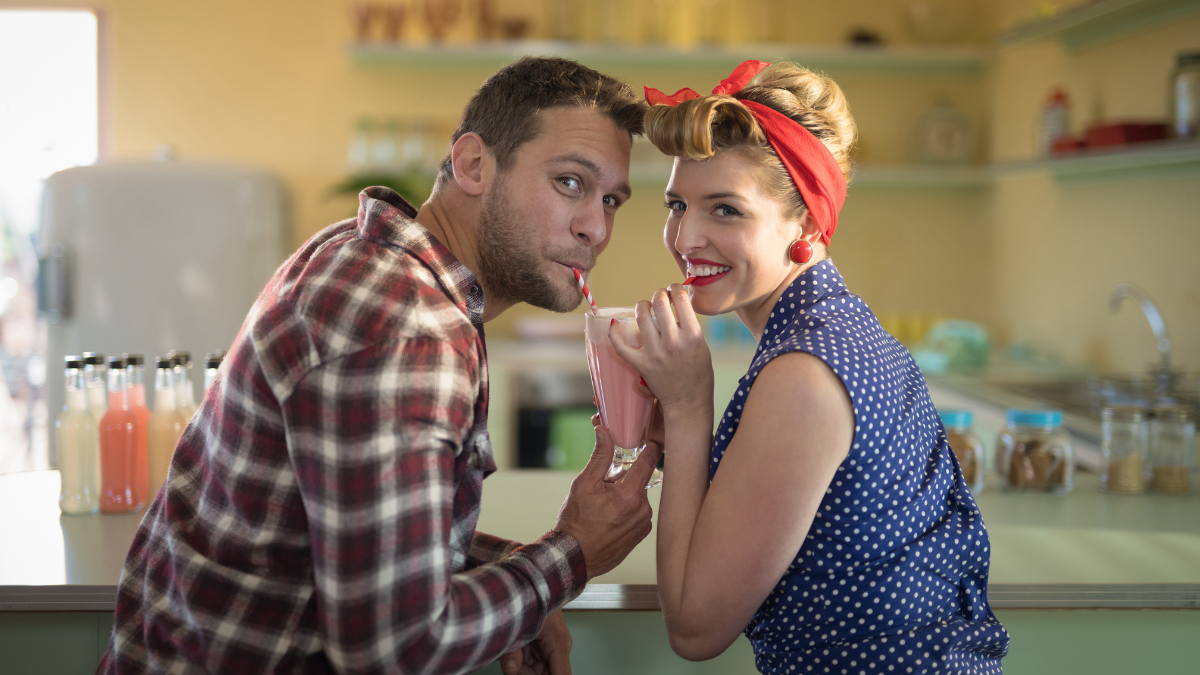 Young couple having milkshake in restaurant.