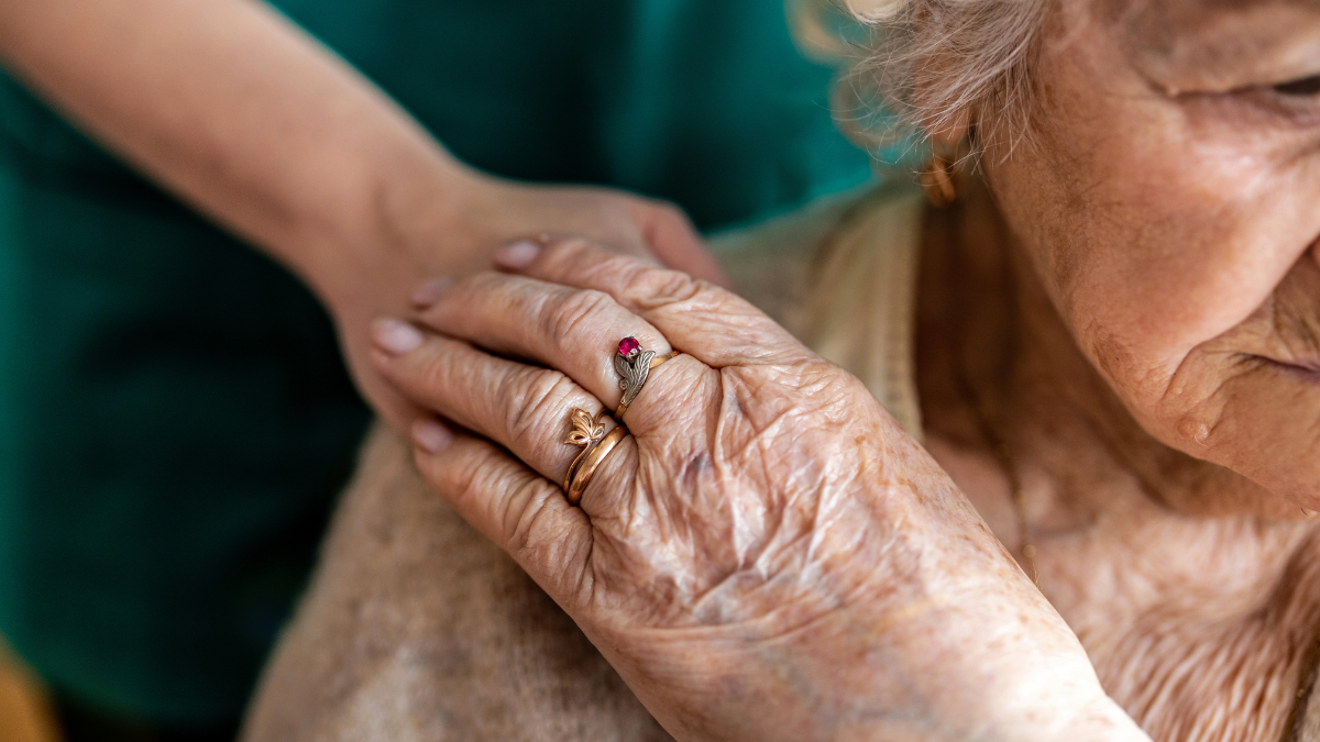 Cropped shot of a senior woman holding hands with a nurse.