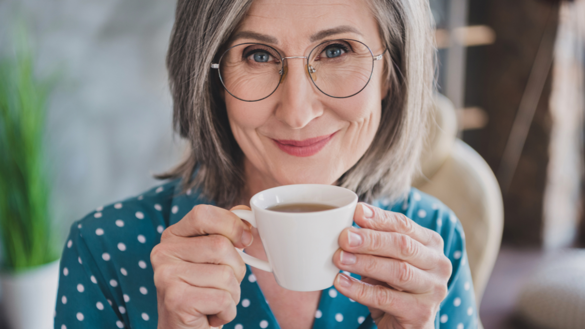 Cropped close-up view portrait of attractive smart cheerful woman drinking espresso at office work station place indoor.