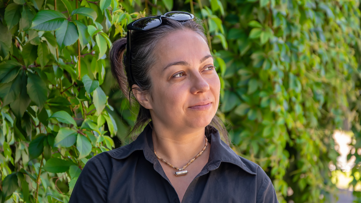 portrait of a beautiful woman 40-45 years old against a background of greenery.
