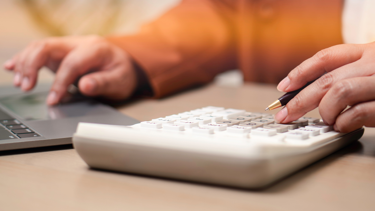 Financial accounting and business budgeting concept. Professional calculating business expenses with calculator and laptop, illustrating finance management, audit, and economic planning.