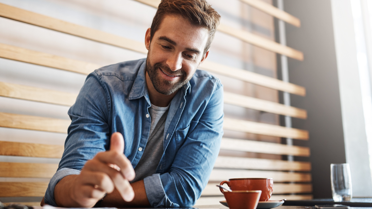 Remote work, smile and tablet with man in coffee shop for planning, research or networking. Happy, technology and freelance employee in cafe or restaurant as customer for hospitality or service.