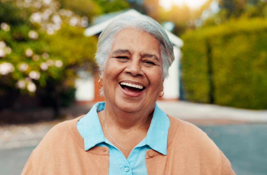 Portrait, outdoor and senior woman at retirement home with laughing, happiness and relax on weekend. Smile, funny and face of elderly female person from Mexico in backyard of nursing facility.