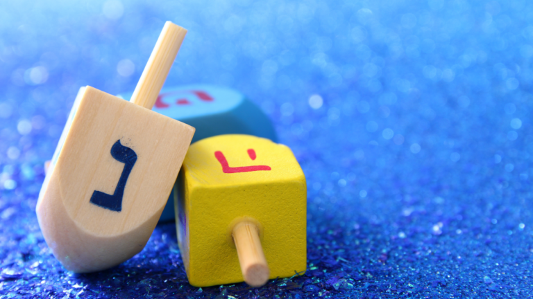 Image of jewish holiday Hanukkah with wooden dreidel (spinning top) on the glitter background.