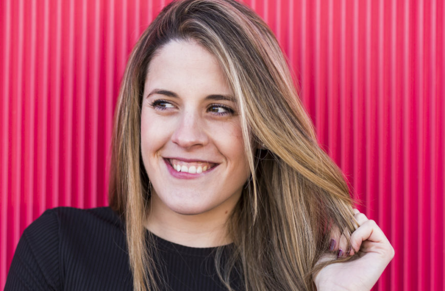 portrait of a beautiful young woman on red background having fun.
