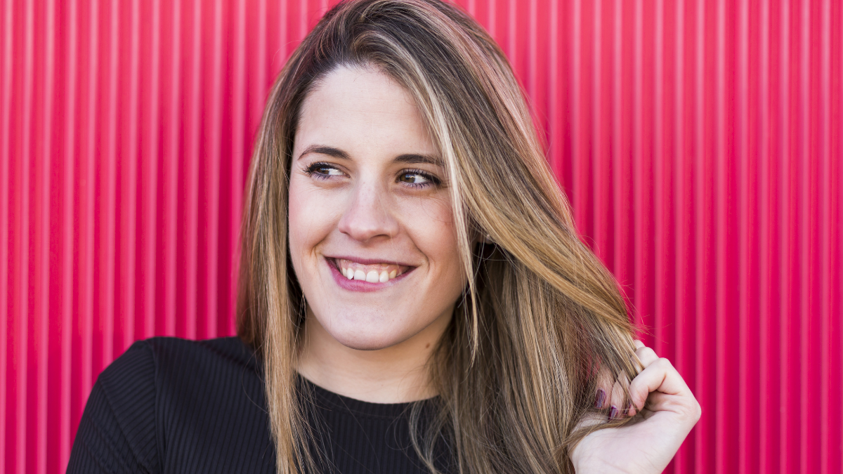 portrait of a beautiful young woman on red background having fun.