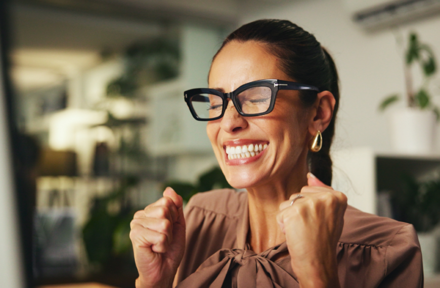 Woman, fist pump and computer for celebration in office, winning competition and salary bonus. Success, financial profit and stock market revenue interest in workplace, investment increase and happy.