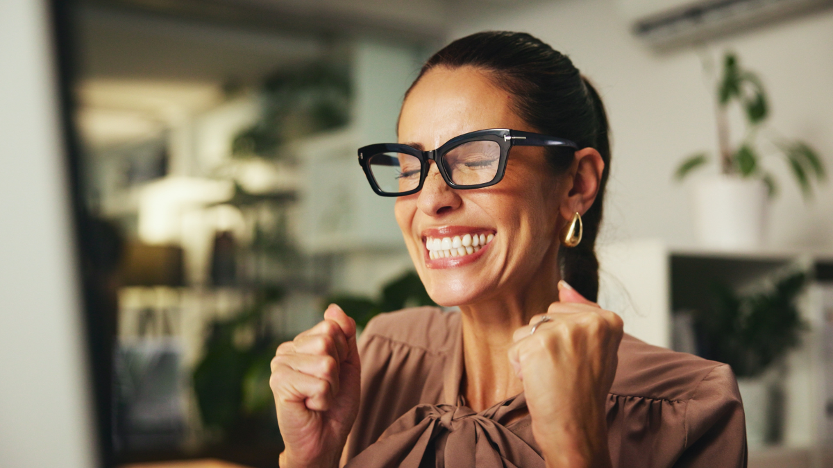Woman, fist pump and computer for celebration in office, winning competition and salary bonus. Success, financial profit and stock market revenue interest in workplace, investment increase and happy.