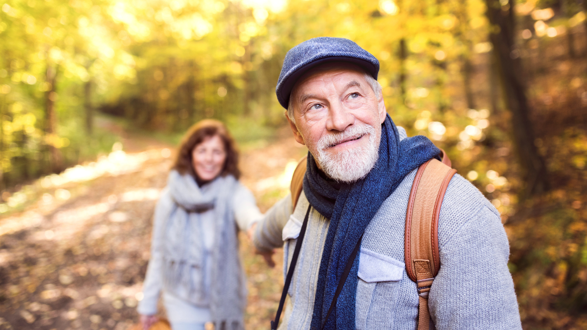 Active senior couple on a walk in a beautiful autumn nature.
