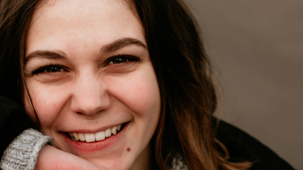 close up portrait of smiling beautiful young woman. street photography.