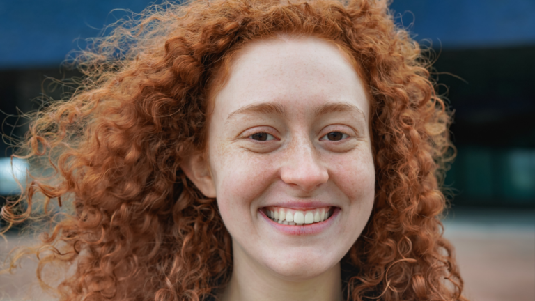 Happy redhead woman smiling on camera.