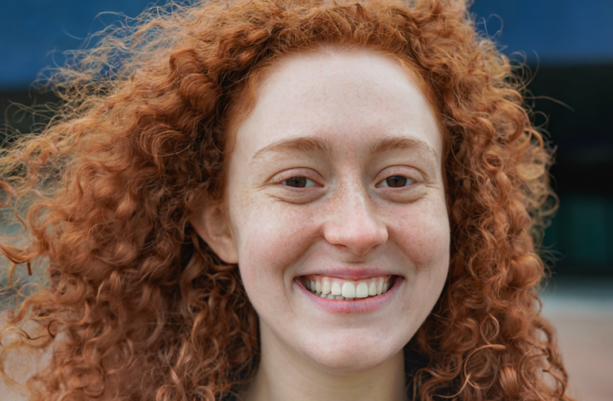 Happy redhead woman smiling on camera.