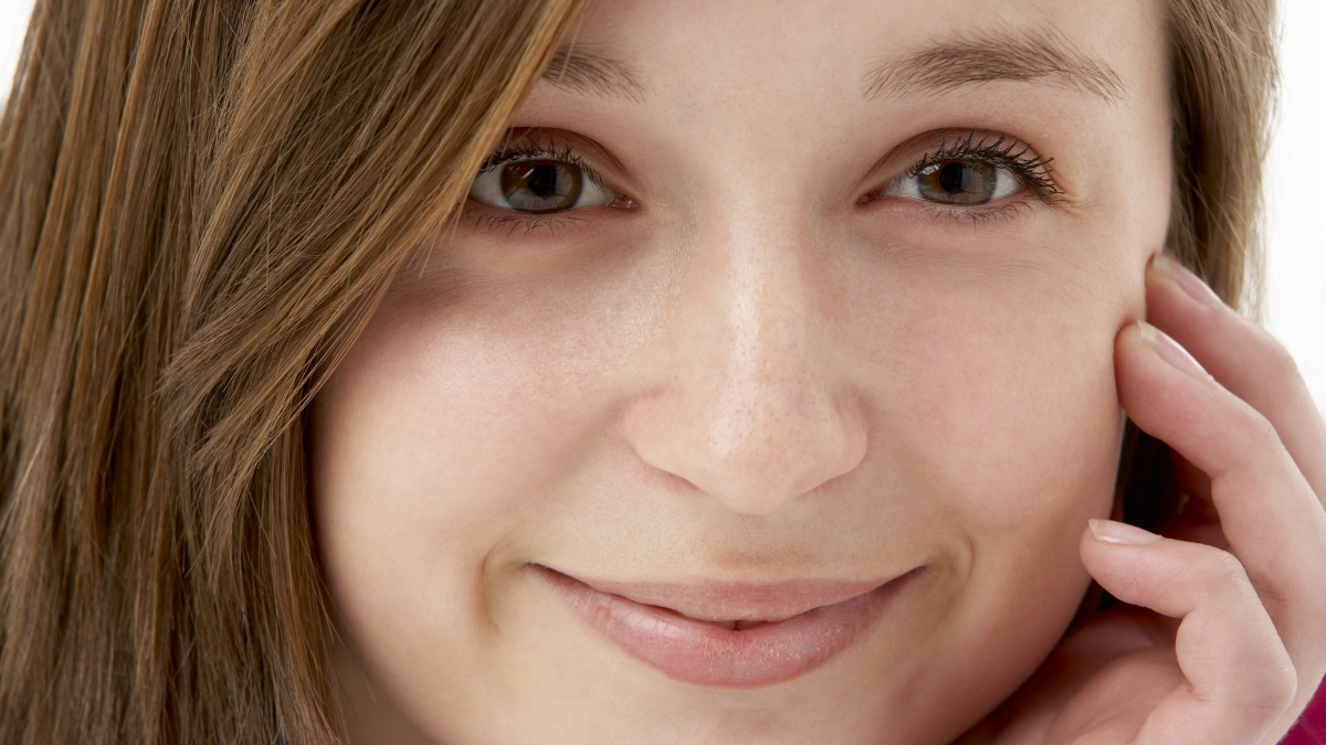 Studio Portrait Of Smiling Teenage Girl.