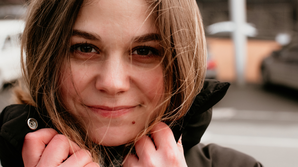 close up portrait of smiling beautiful young woman. street photography.