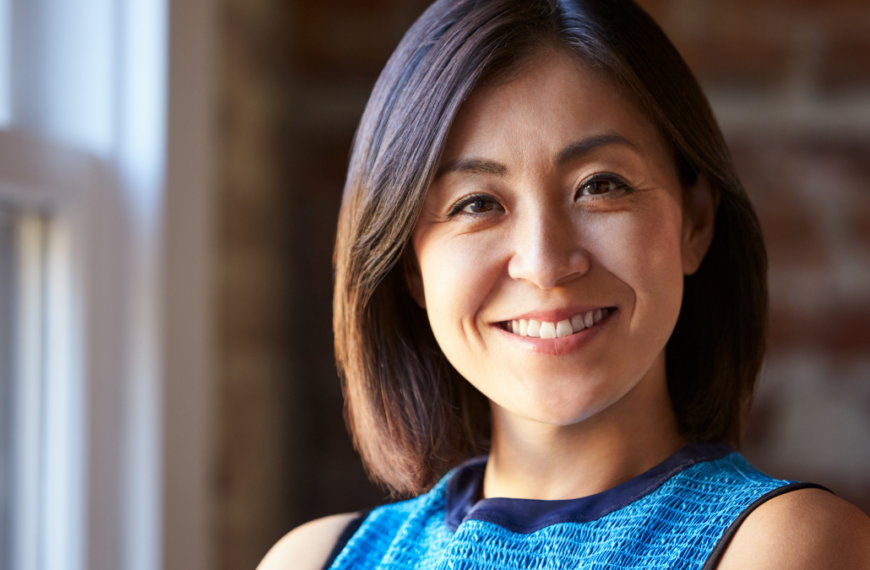 Portrait Of Businesswoman In Office Standing By Window.