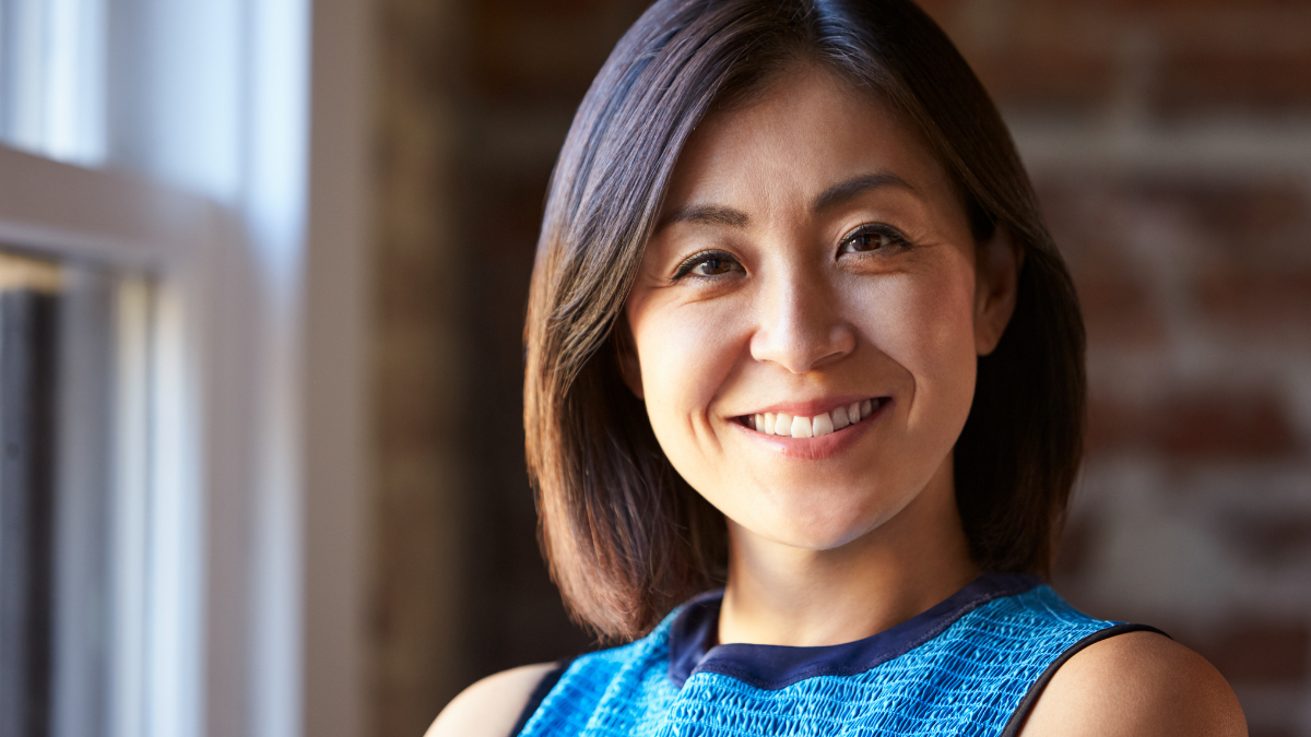 Portrait Of Businesswoman In Office Standing By Window.