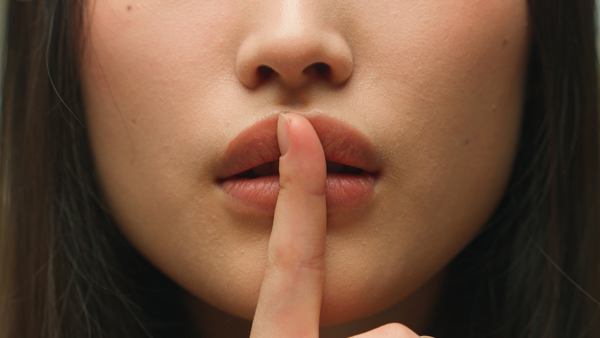 Silence gesture extreme close up female mouth Asian chinese korean japanese woman unrecognizable lady girl hush lips keep secret silent whisper quite secrecy confidential mysterious model face details.