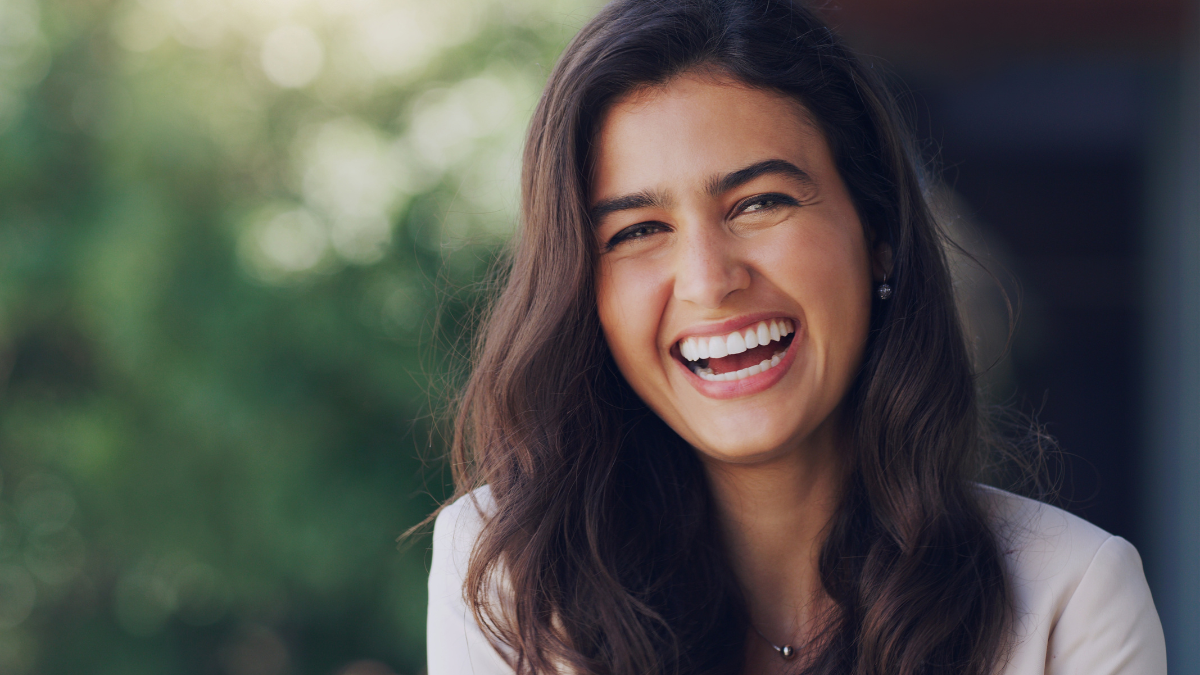Happy, woman and face in nature for portrait, positive mindset and carefree with mockup space. Female person, smile and inspiration in natural environment for success, peace and relaxing in Portugal.
