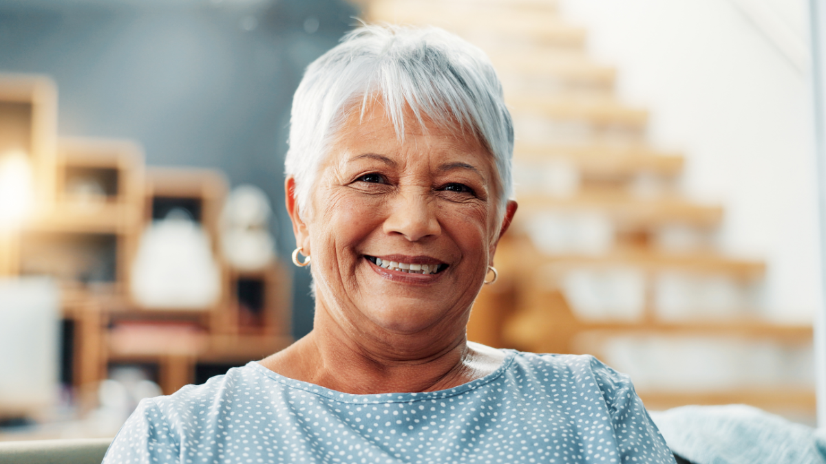 Senior, woman and happy with portrait in home for relax, comfortable and peaceful in retirement. Elderly person, smile and confidence on sofa for mortgage insurance, security and wellness in lounge.