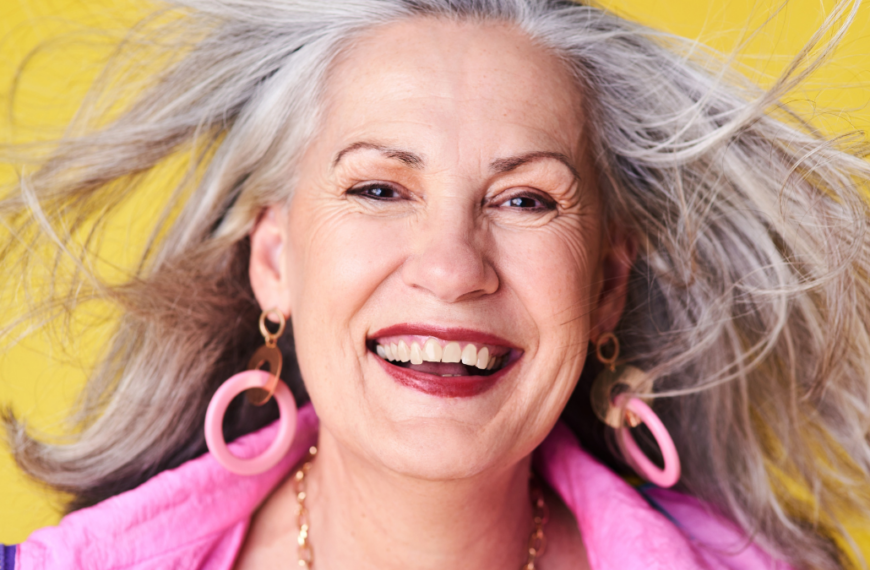 Portrait, fashion and cool senior woman in studio with smile, confidence and creative retirement. Happy, face and trendy elderly person with fun style, positive attitude or pride on yellow background old-fashioned frugal living tip.