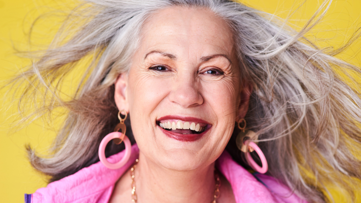 Portrait, fashion and cool senior woman in studio with smile, confidence and creative retirement. Happy, face and trendy elderly person with fun style, positive attitude or pride on yellow background old-fashioned frugal living tip.