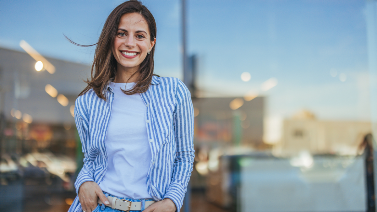 Young latin woman in casual clothing in the street looking at camera, during early morning. Portrait of healthy girl enjoying during sunset. Mindful multiethnic woman enjoy.