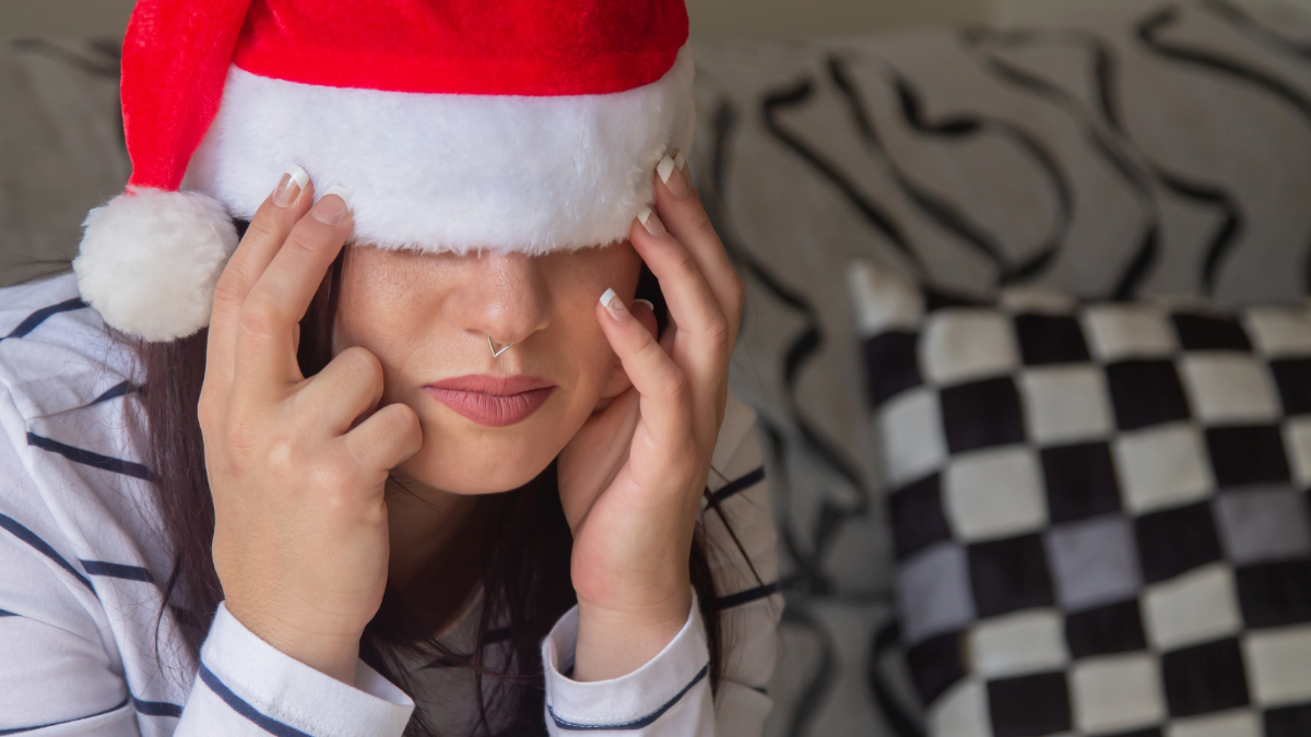 Depressed young woman in Santa hat feeling lonely and sad on Christmas holidays.