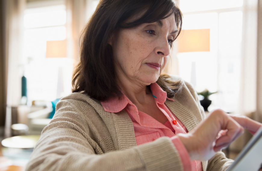 Woman using digital tablet in living room.
