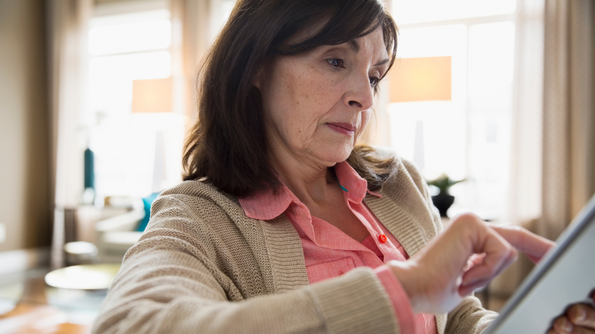 Woman using digital tablet in living room.