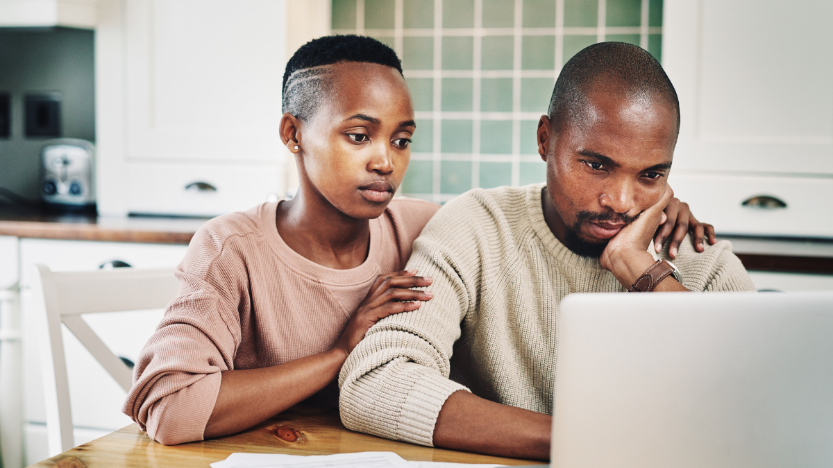 Black couple, home and stress on kitchen table with laptop for bills, debt and loan interest rate. People, relationship and sad with digital invoice for budget plan or savings with paperwork.