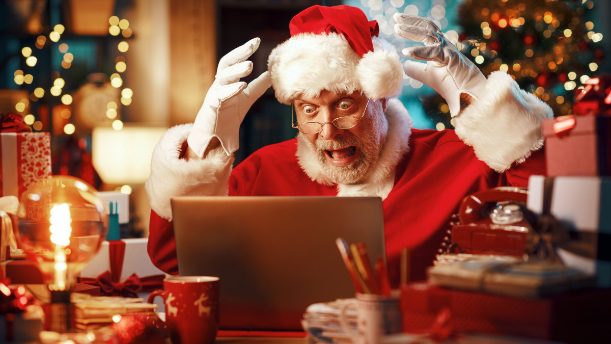 Shocked stressed Santa Claus having problems with his laptop on Christmas Eve.
