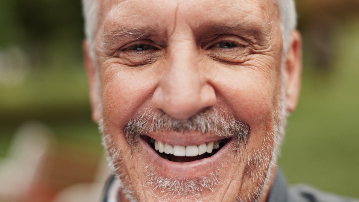 Outdoor, mature man and happy in portrait for vacation, travel holiday and adventure with pride. Nature, male person and smile with satisfaction for dental care, teeth wellness and laugh by closeup.