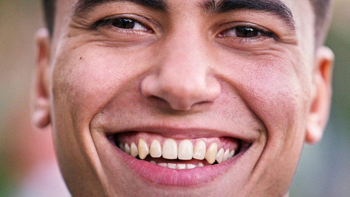 Happy man, university and closeup in park for scholarship, education and future goals with portrait smile. Student, college or academy campus for learning, commute and pride with satisfaction.