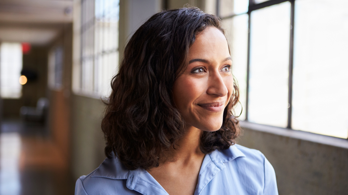Smiling young mixed race businesswoman looking away.