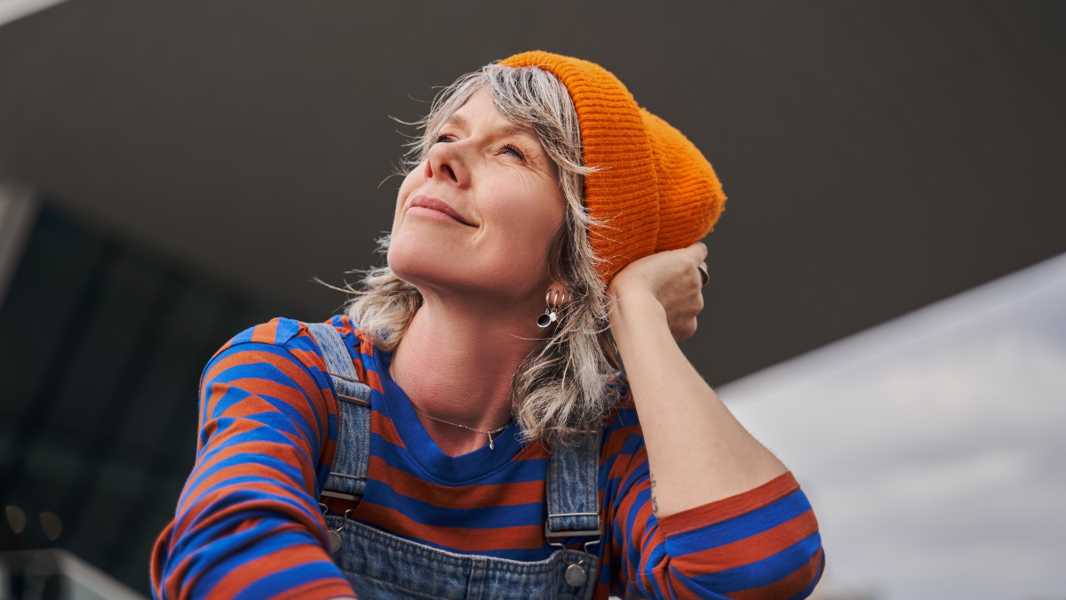Dreamy adult woman sitting and looking away while relaxing alone.