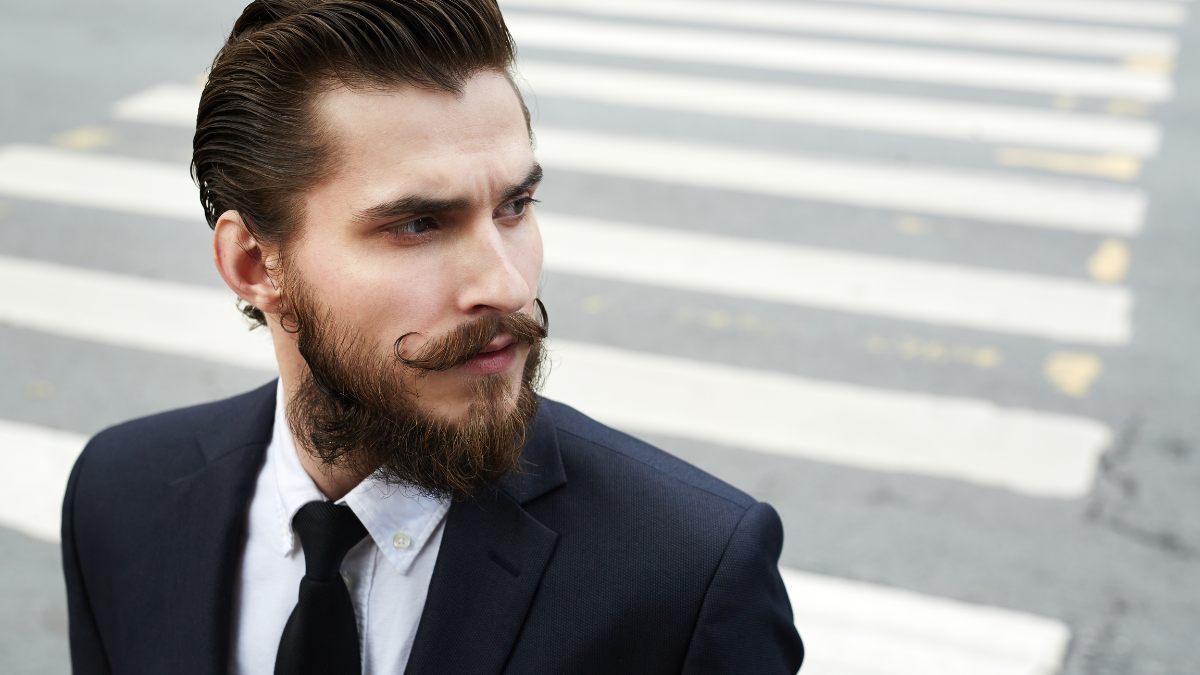 Attractive and elegant man with beard and moustache wearing suit.