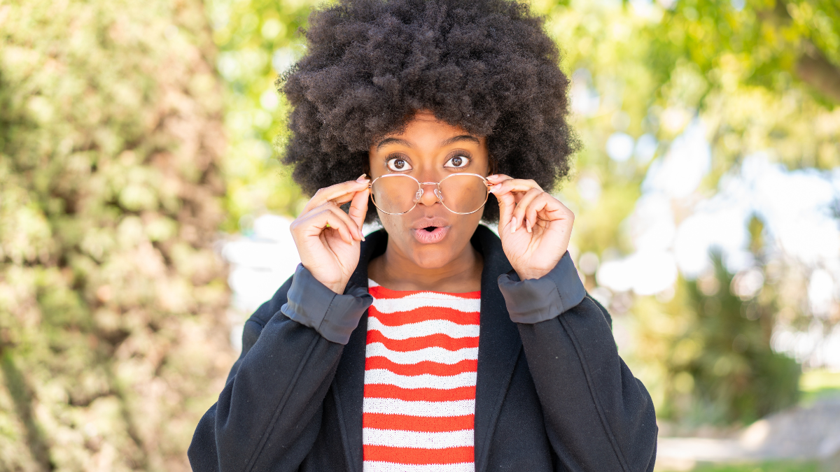 African American girl at outdoors With glasses and surprised expression.