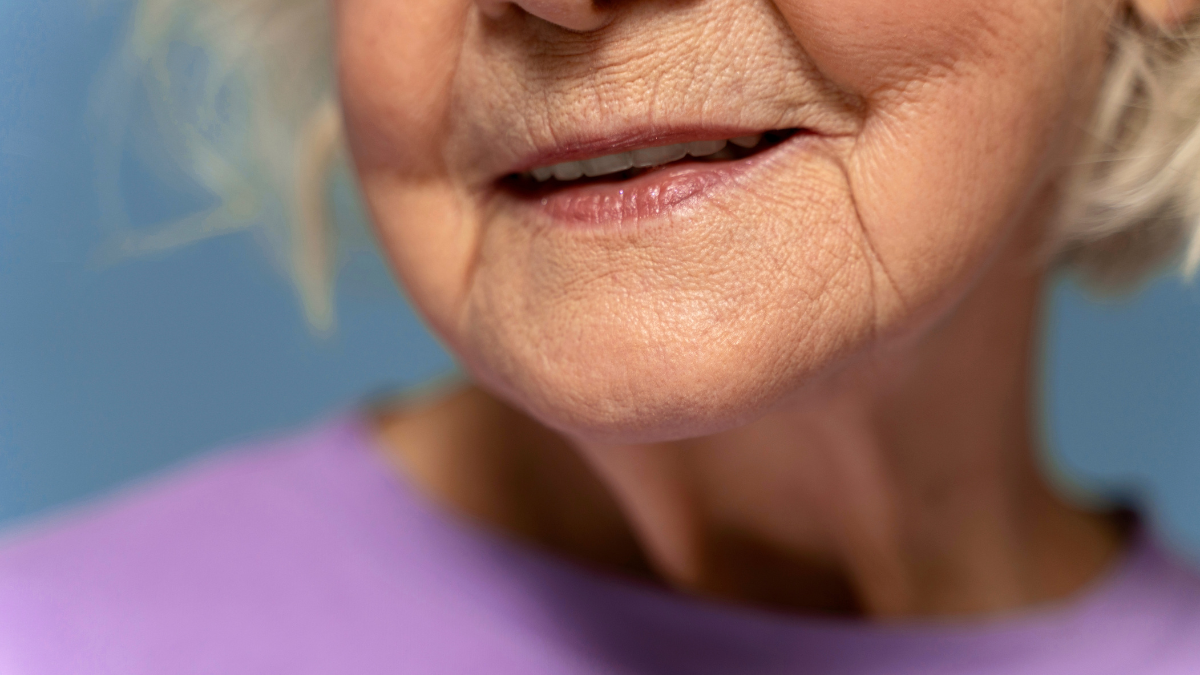 Close up of cropped senior woman wearing t-shirt. Isolated on blue background.