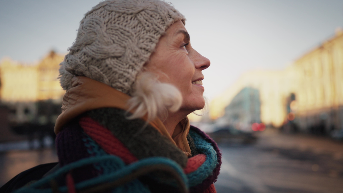 Frustrated foreign tourist woman standing alone on square in downtown, portrait. Sightseeing and tourism in Europe, mature female traveler viewing old architecture, examining history, slow motion.