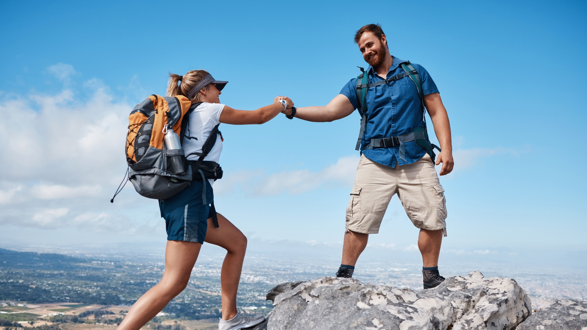 Help, couple or friends hiking on mountain in nature with a smile or training. Travel, adventure and trekking workout man and woman on an outdoor, countryside or rock climbing, exercise and support.