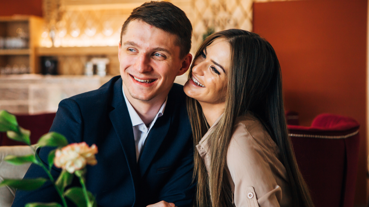 Happy young couple taking selfie with smart phone at cafe.