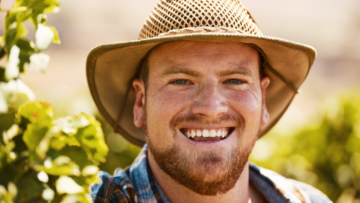 Happy man, portrait and farmer with hat for natural growth, agriculture or harvest in countryside nature. Face of young male person or gardener with smile for farming, ecology or conservation on land.