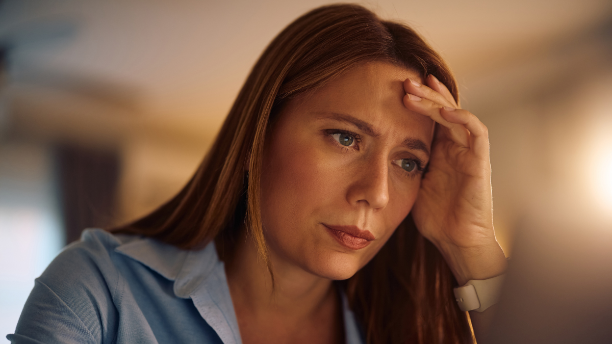 Distraught businesswoman reading an e-mail while working on laptop at home.