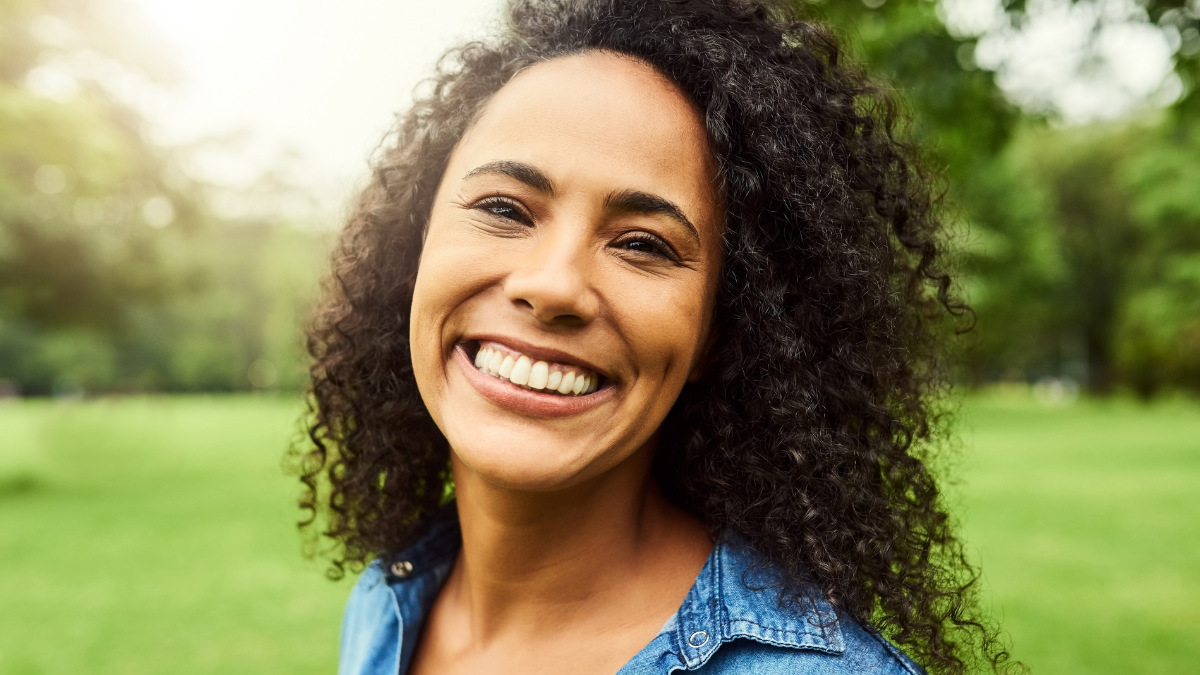 Girl, portrait and park activity of young person happy about nature, travel and freedom. Face, smile and laughing woman with New York, countryside and garden relaxing for summer fun and health.