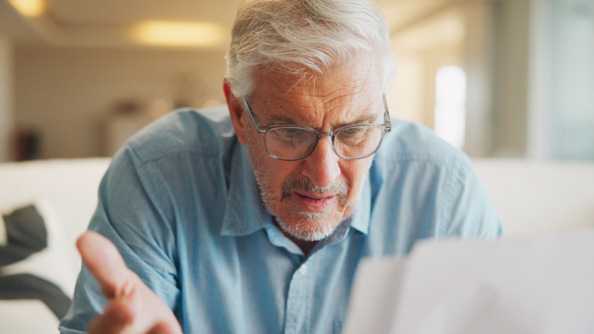 Documents, confused and old man in home with stress, angry or question for insurance on sofa. Shocked, frustrated and senior person reading paperwork for decision, mistake or financial report,