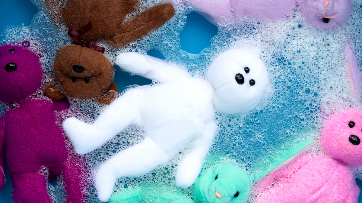 Soak toy teddy bear in laundry detergent water dissolution before washing. Laundry concept.