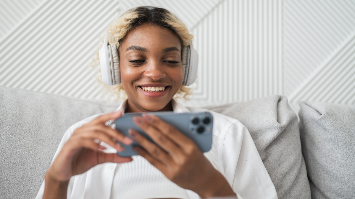 Happy smiling girl watching video,streaming service,movie on smartphone at home. Modern technologies,applications . Legal and Free Movie Apps.