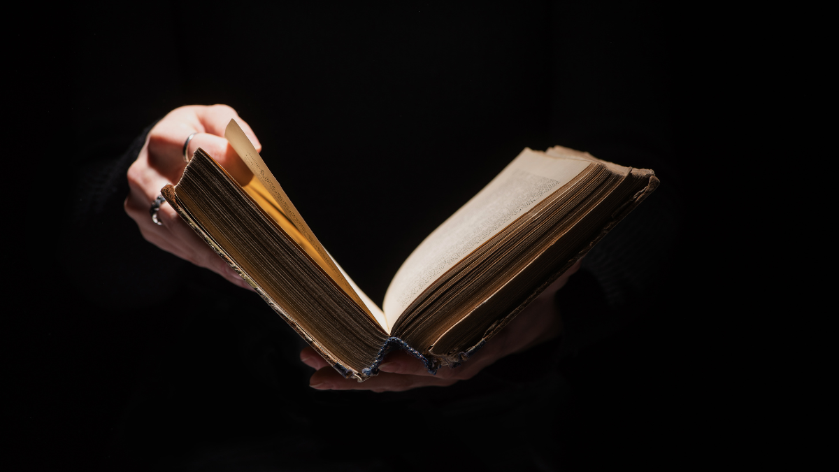 ropped view of woman holding old book isolated on black Things To Know Before Investing in Rare Books.